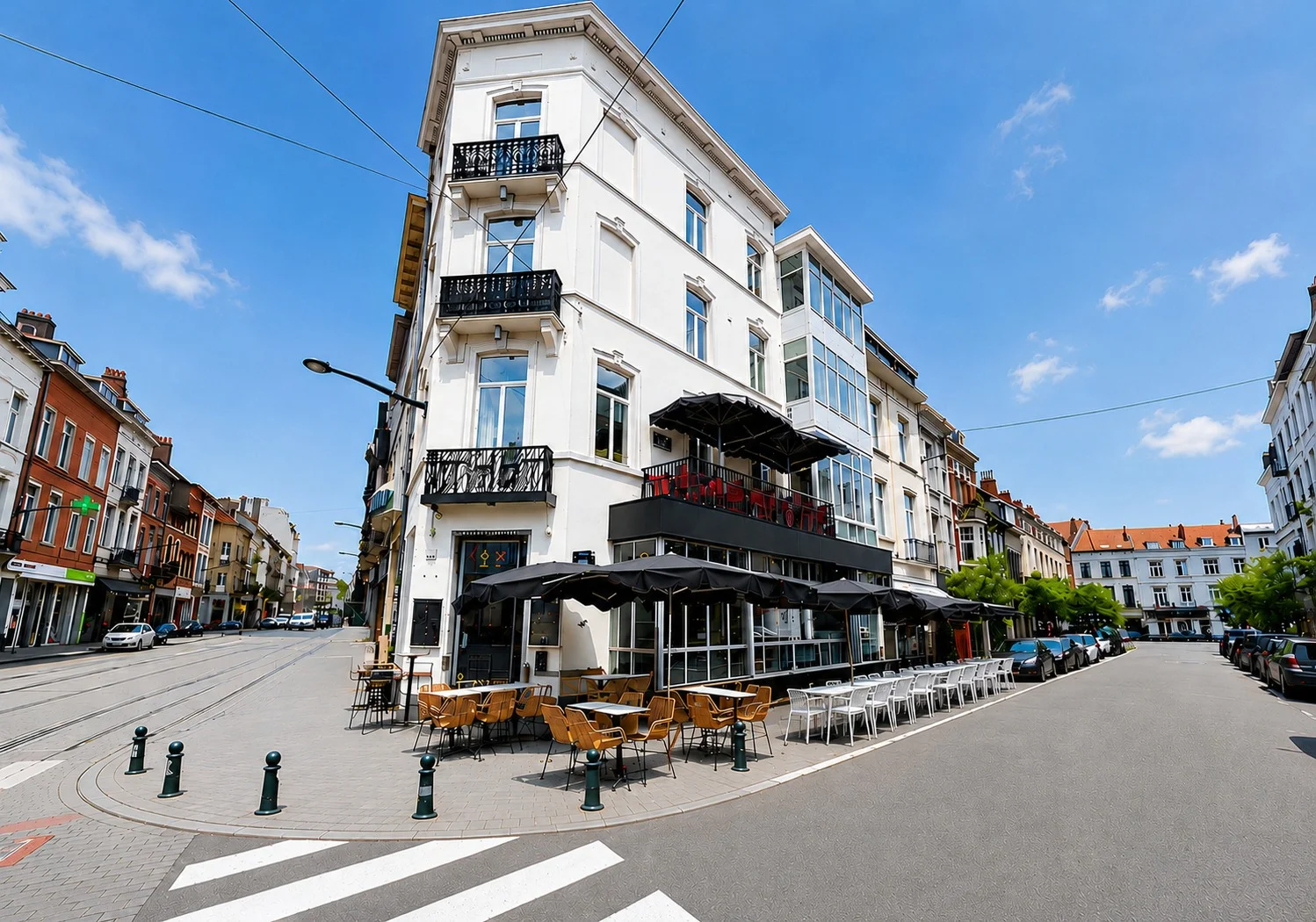 Façade d'angle du ROXI, rue du Bailli au Châtelain (Ixelles), avec terrasse et parasols noirs