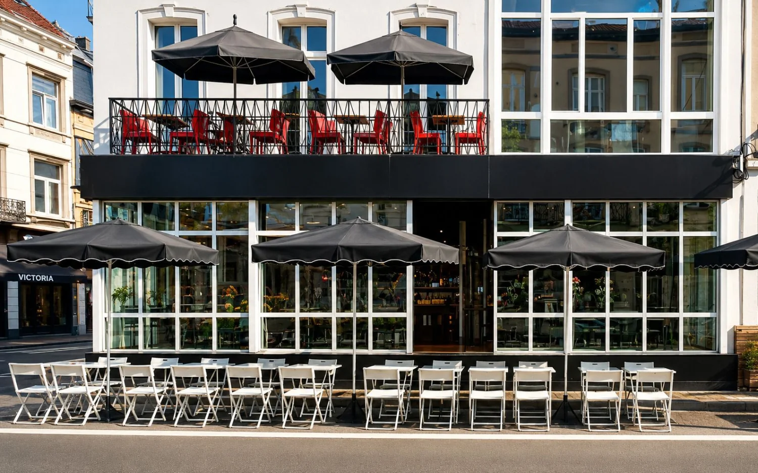 Façade du ROXI : terrasse en rez-de-chaussée et balcon-terrasse à l'étage aux chaises rouges, rue du Bailli